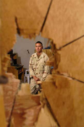 Spc. Ramon Garcia, 27, from Miami, with the 1st Battalion, 505th Parachute Infantry Regiment, 82nd Airborne Division, was on his rack listening to music Saturday when a 57mm rocket punched through a plywood wall into his room in Fallujah, Iraq. It failed to detonate when it hit the concrete wall on the other side of the room.  Rob Curtis / Military Times staff