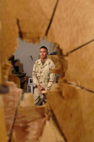 Spc. Ramon Garcia, 27, from Miami, with the 1st Battalion, 505th Parachute Infantry Regiment, 82nd Airborne Division, was on his rack listening to music Saturday when a 57mm rocket punched through a plywood wall into his room in Fallujah, Iraq. It failed to detonate when it hit the concrete wall on the other side of the room. Rob Curtis / Military Times staff